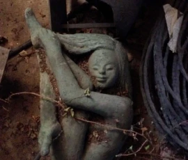 Scultura in bronzo Fotografia di un ritrovamento all'interno di una casa abbandonata. Una grande scultura in bronzo di Lalla Vanzella. Una figura femminile in posizione fetale avvolta dall'edera entrata dal giardino.