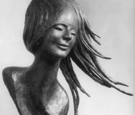 Scultura in bronzo Fotografia in bianco e nero, bronzo di Lalla Vanzella, volto di giovane donna sorridente, con i capelli agitati dal vento.