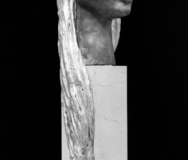 Scultura in bronzo Fotografia in bianco e nero, scultura di Lalla Vanzella in bronzo con piedistallo in marmo. Volto femminile con lunghi capelli che scendono nella struttura di marmo.